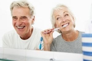 Smiling Older Couple Brushing Teeth