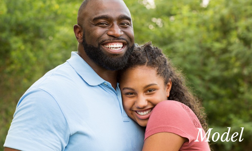 Father with Large Smile Hugging Young Daughter